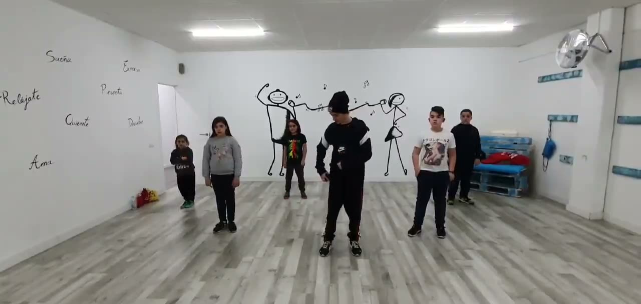 Grupo de niños y niñas bailando con su profesor en una sala de RecchiaDanza